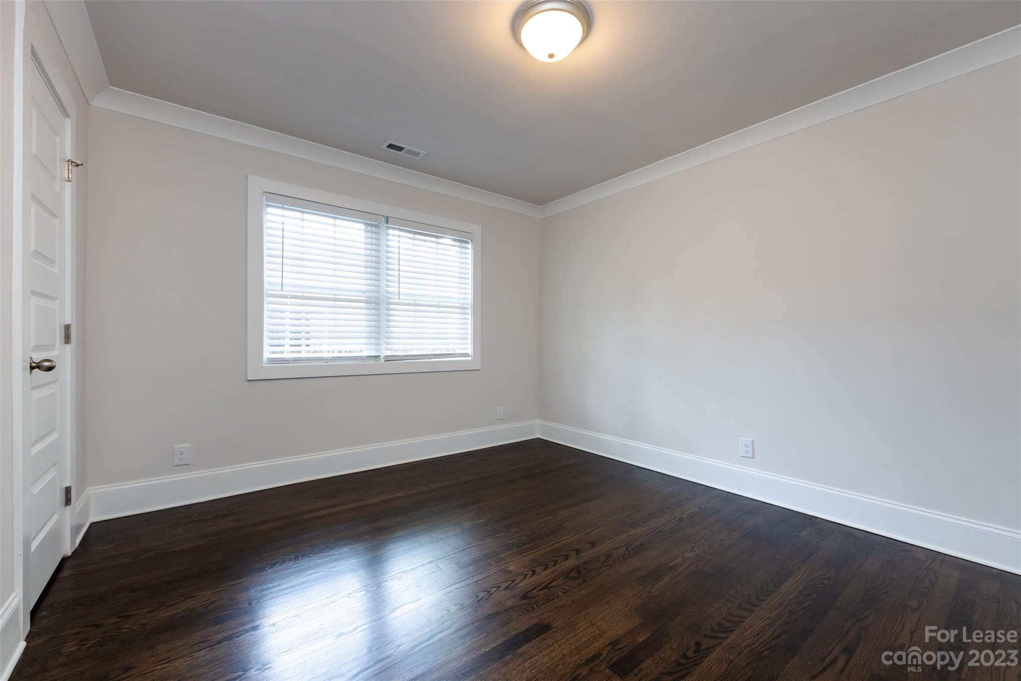 1704 Club Road, Unit A Charlotte, NC 28205 - Photo 23 of 35 a view of an empty room with wooden floor and a window