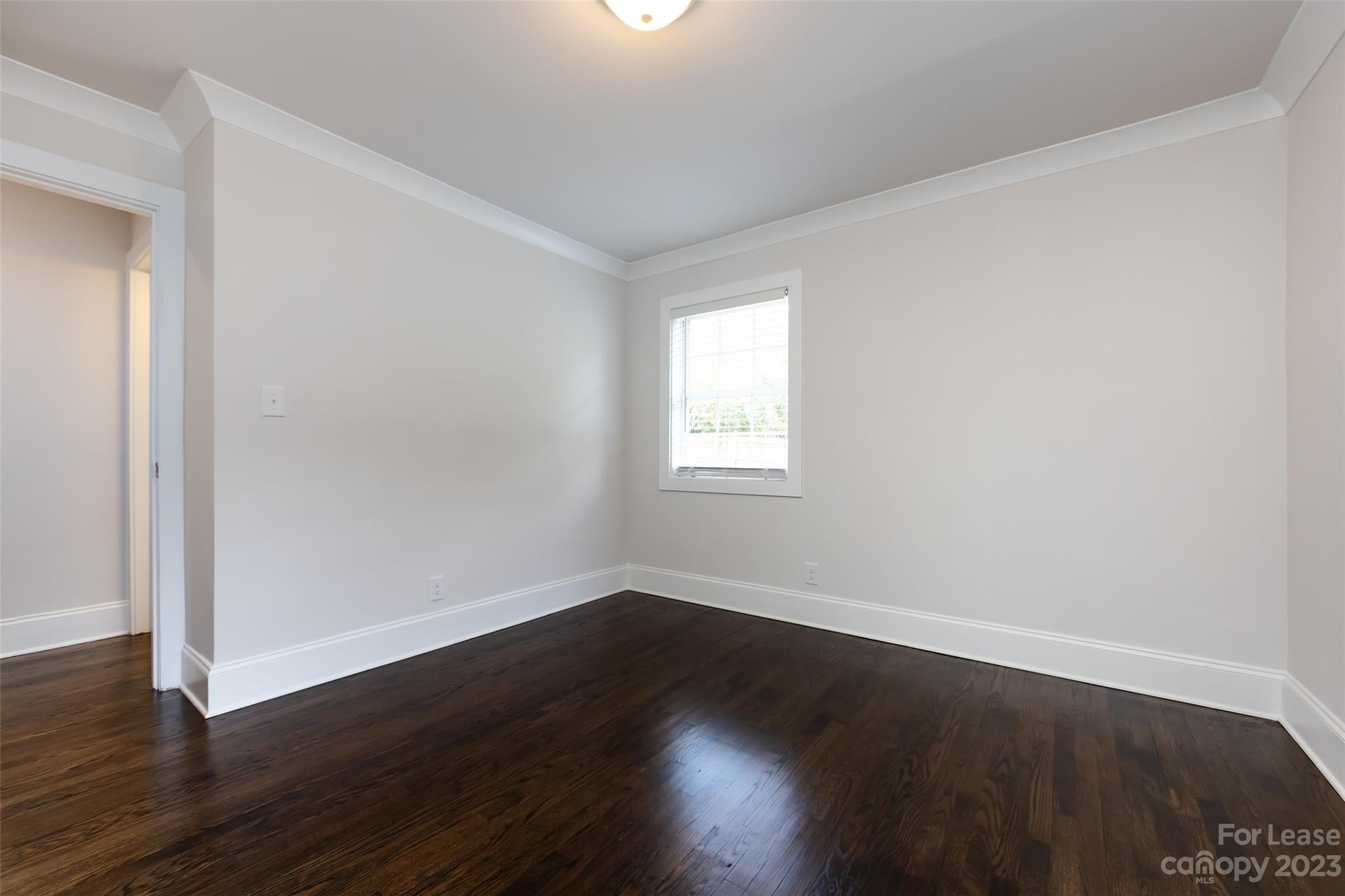1704 Club Road, Unit A Charlotte, NC 28205 - Photo 28 of 35 an empty room with wooden floor and windows