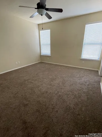 an empty room with a window and a ceiling fan
