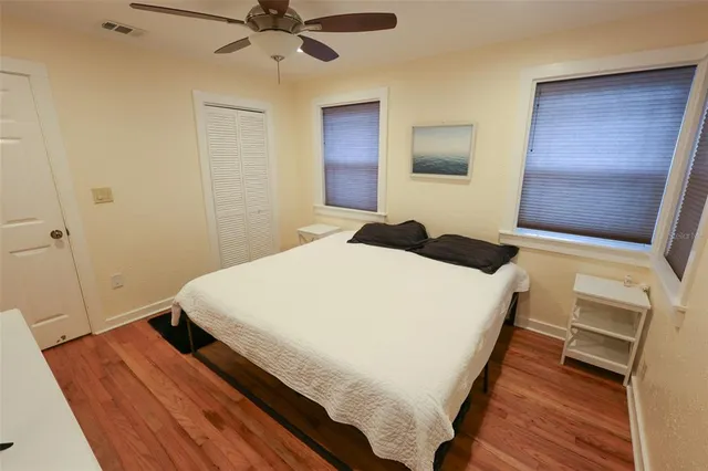 a bedroom with a bed and a flat tv screen on a dresser