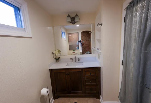 a bathroom with a sink a light fixture and a mirror