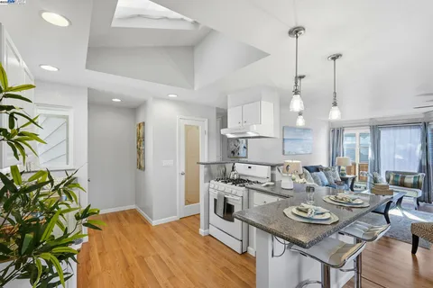 a dining room with furniture a chandelier and wooden floor