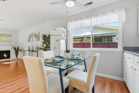 a kitchen with stainless steel appliances kitchen island granite countertop a sink a stove a table and chairs