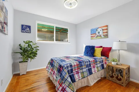 a bedroom with a bed and a painting on the wall