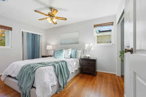 a bedroom with a bed and painting on the wall