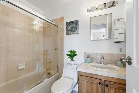 a bathroom with a sink toilet a mirror and shower