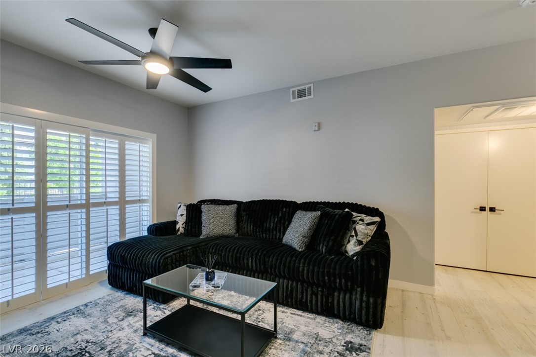 7255 West Sunset Road, Unit 1103 Las Vegas, NV 89113 - Photo 9 of 35 Sliding glass doors with full shutters and a contemporary ceiling fan define this inviting living space.