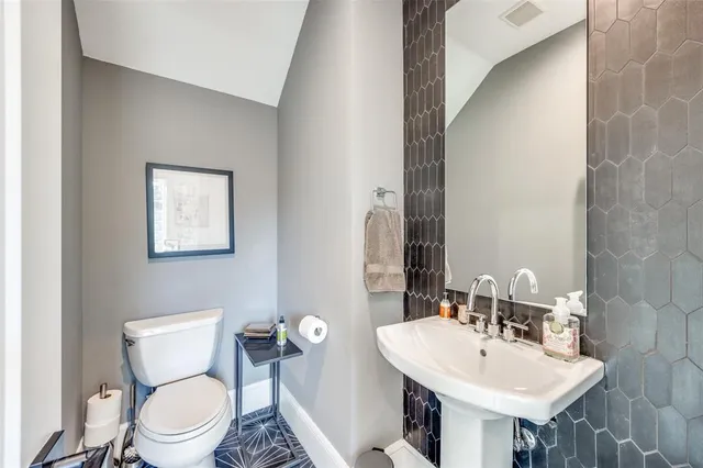 a bathroom with a toilet a sink and a mirror