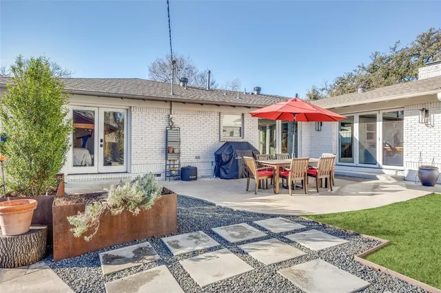 a view of a patio with table and chairs under an umbrella