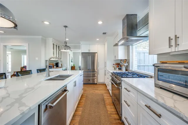 a large kitchen with kitchen island a large counter space a sink appliances and cabinets