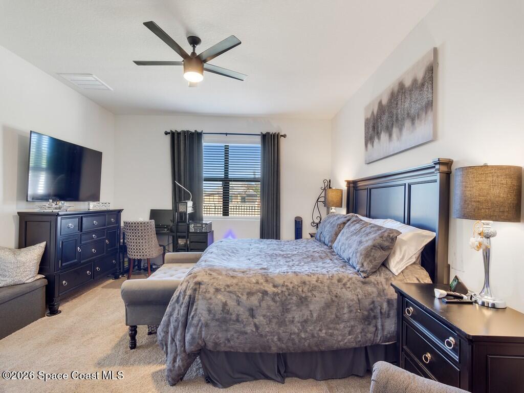 645 Old Country Rd S East Palm Bay, FL 32909 - Photo 16 of 42 a bedroom with a bed and a flat screen tv