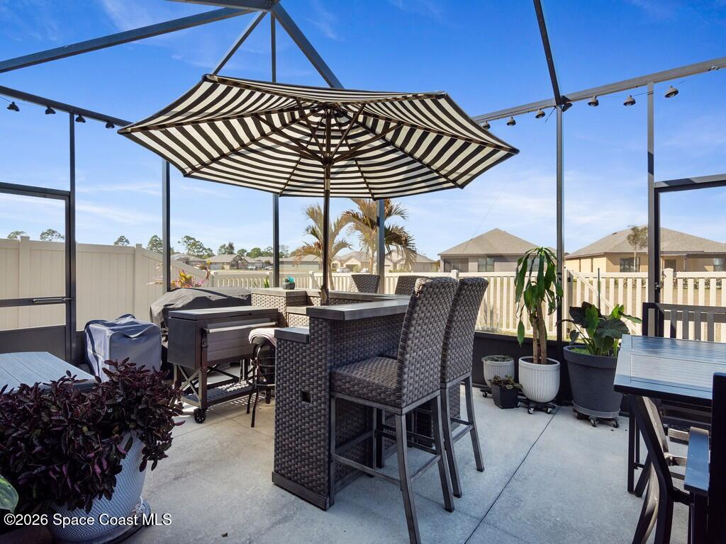 645 Old Country Rd S East Palm Bay, FL 32909 - Photo 18 of 42 a view of balcony with chairs and table under an umbrella