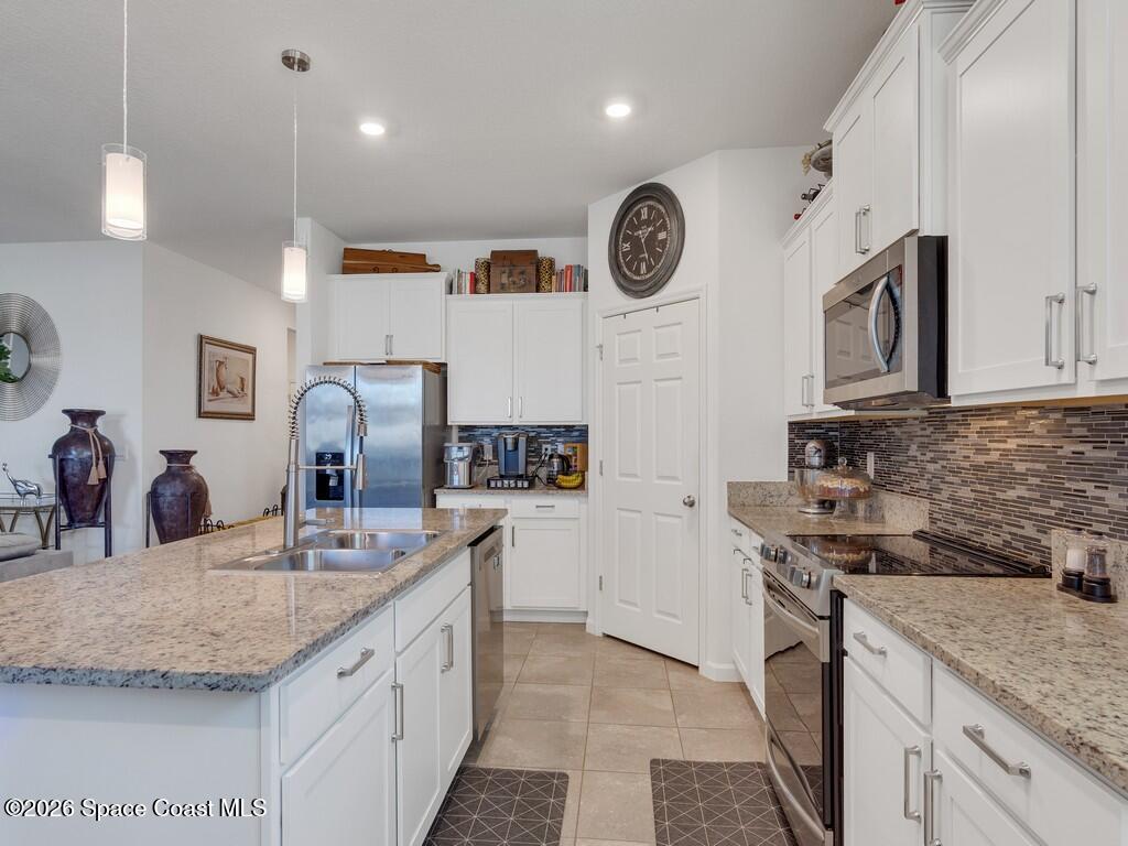 645 Old Country Rd S East Palm Bay, FL 32909 - Photo 3 of 42 a kitchen with a sink stove and cabinets