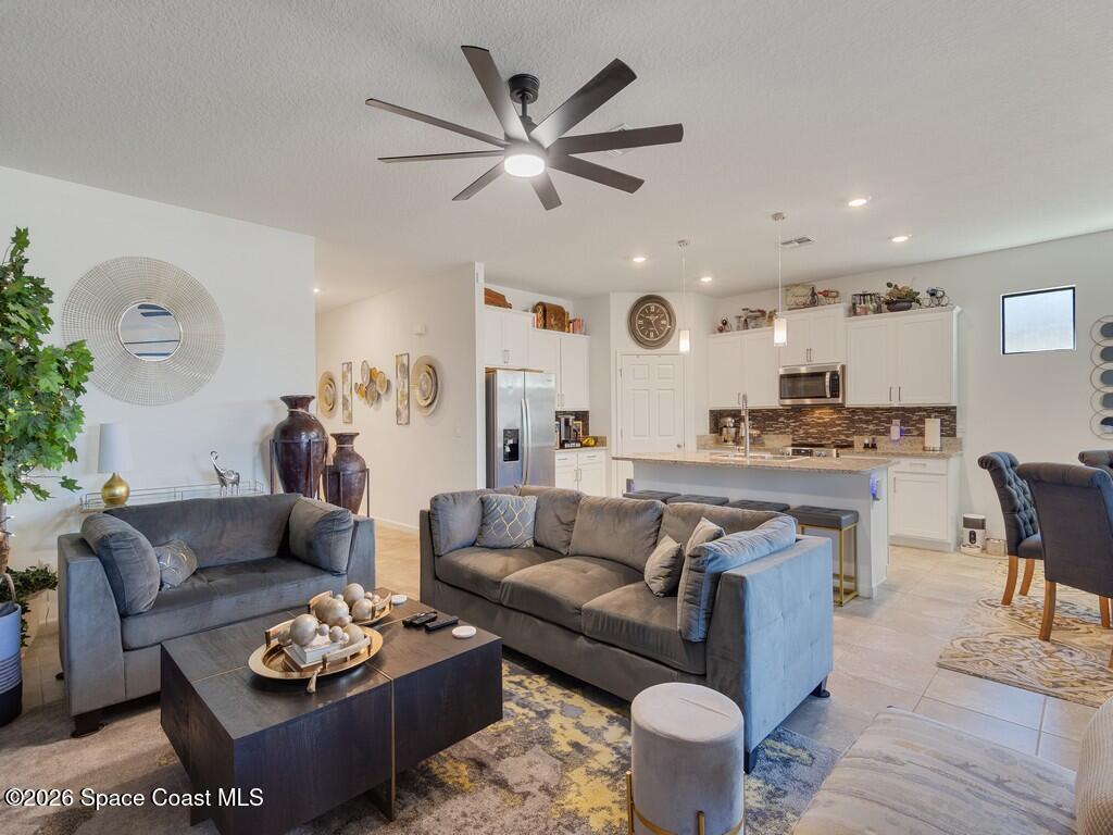 645 Old Country Rd S East Palm Bay, FL 32909 - Photo 5 of 42 a living room with furniture kitchen view and a chandelier