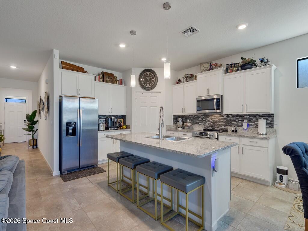 645 Old Country Rd S East Palm Bay, FL 32909 - Photo 10 of 42 a kitchen with stainless steel appliances a sink a stove a refrigerator cabinets and a refrigerator
