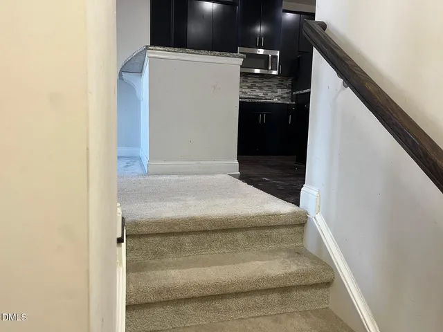a bathroom with a granite countertop sink and washing machine