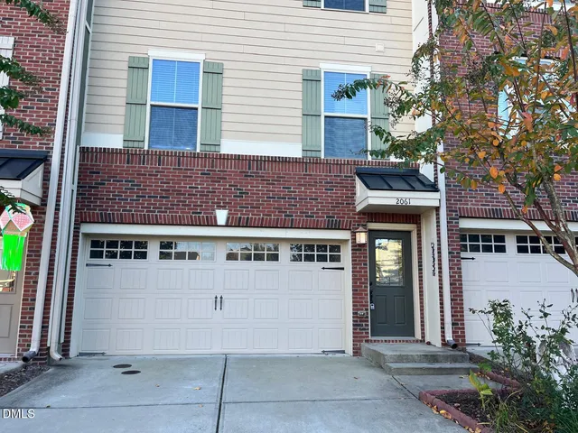 a view of a building with a door and a tree