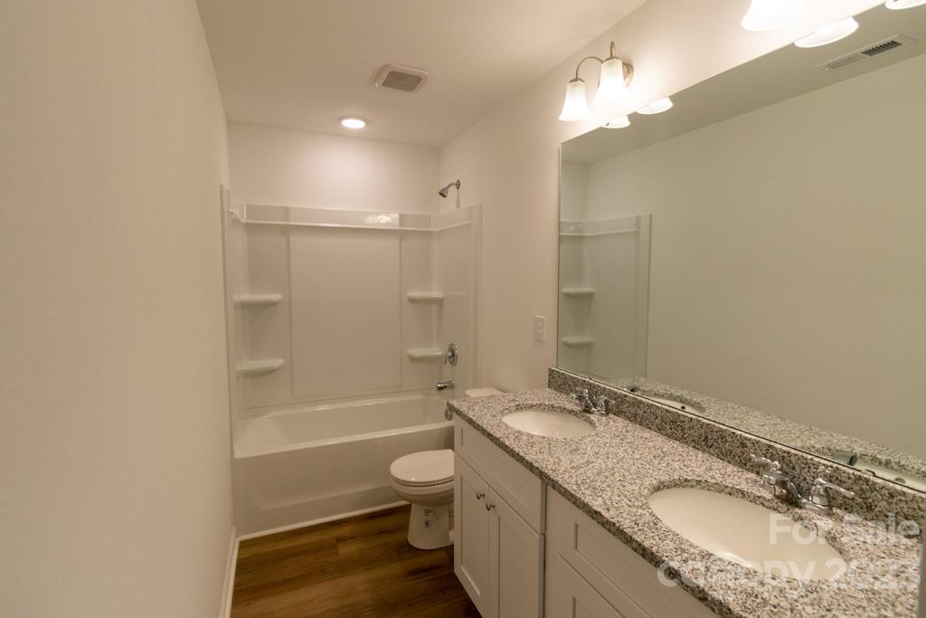 2173 Country Club Drive Lancaster, SC 29720 - Photo 14 of 18 a bathroom with a granite countertop sink a toilet a mirror and shower
