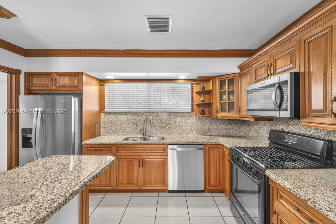 12310 Southwest 39th Terrace Miami, FL 33175 - Photo 9 of 42 a kitchen with a stove sink and cabinets