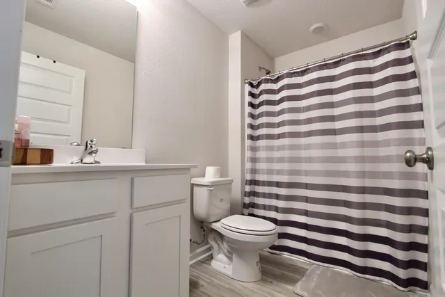 a view of a hallway with a room space and wooden floor