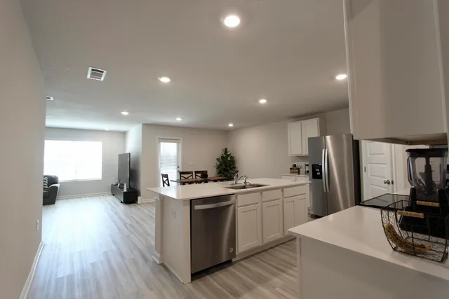 a kitchen with white cabinets and stainless steel appliances