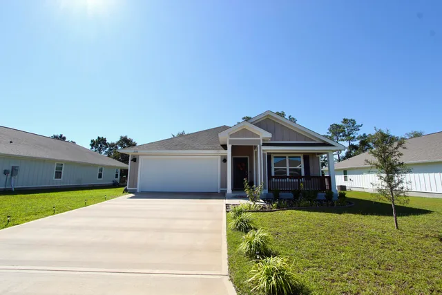 a front view of a house with yard and green space