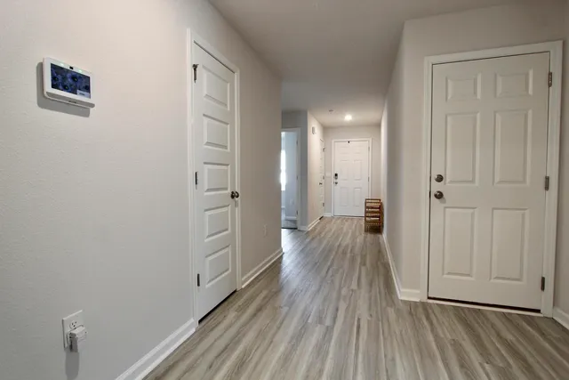 a view of a hallway with wooden floor and closet area