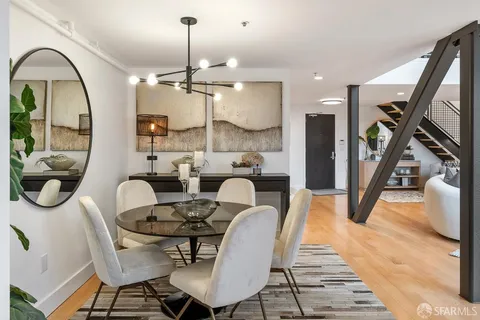 a view of a dining room with furniture a rug and wooden floor