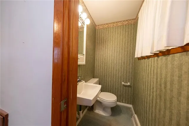 a bathroom with a toilet a sink and shower curtain