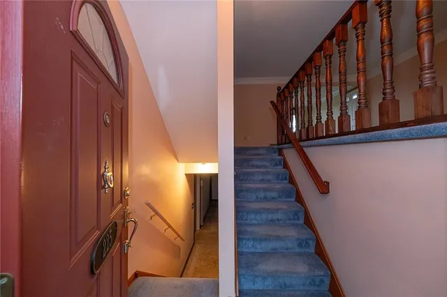 a view of staircase with railing and a chandelier