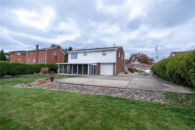 a view of a house with a big yard and a large tree