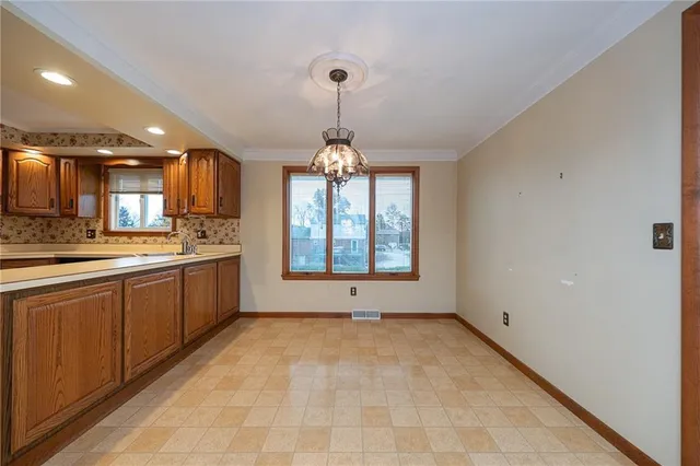 a large kitchen with lot of cabinets and a window