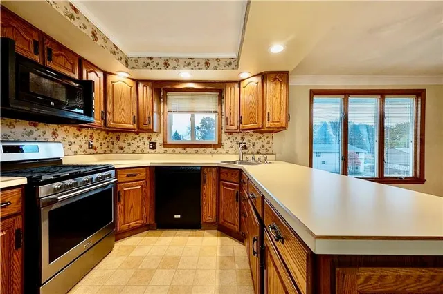 a kitchen with stainless steel appliances a stove sink microwave and cabinets