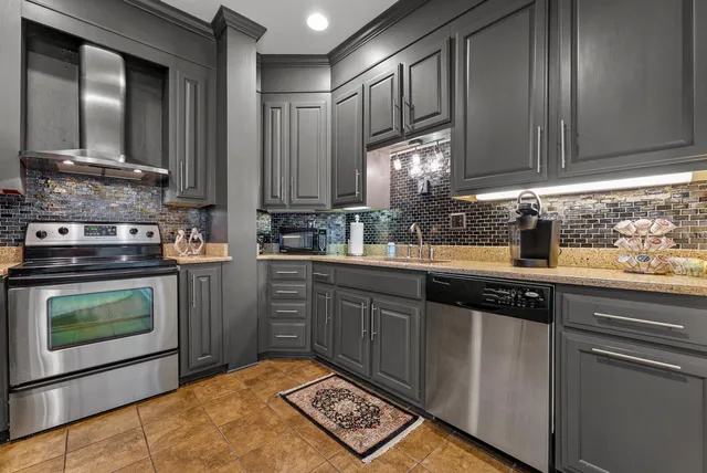 a kitchen with stainless steel appliances granite countertop a sink stove and cabinets