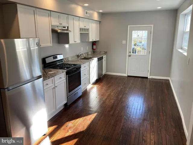 a kitchen with stainless steel appliances a refrigerator and a stove top oven