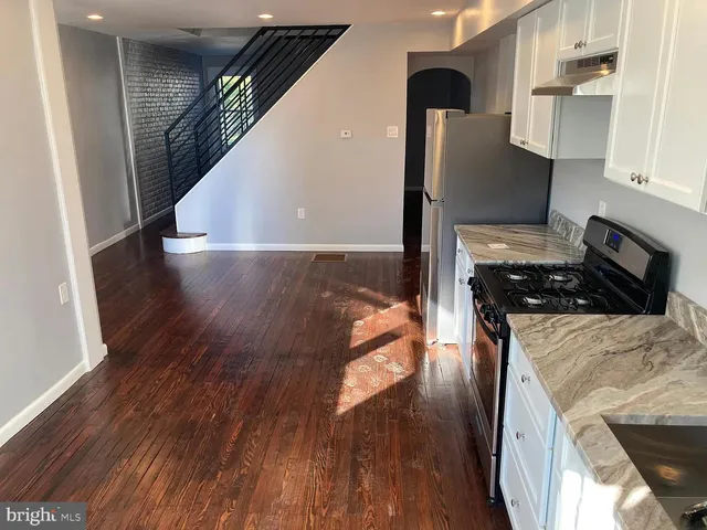 a kitchen with a refrigerator and a stove top oven