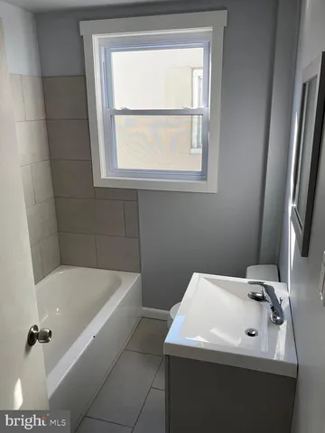 a bathroom with a sink a bathtub and a window