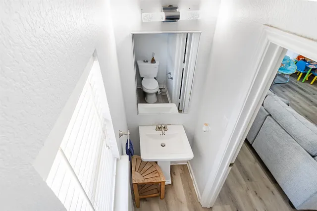 a view of staircase with lots of frames on wall and a window