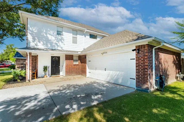 a front view of a house with a garden and plants