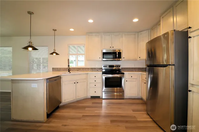 a kitchen with a refrigerator a sink and dishwasher a oven with wooden floor