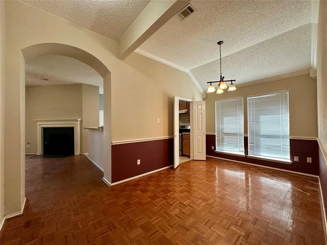 a view of a livingroom with a fireplace a chandelier and windows