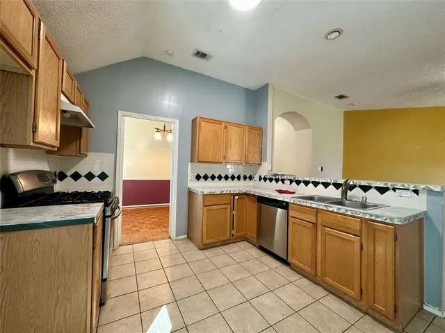 a kitchen with stainless steel appliances granite countertop a sink and cabinets