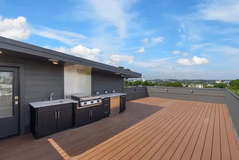 a dining hall with stainless steel appliances granite countertop a stove a sink a dining table and chairs with wooden floor