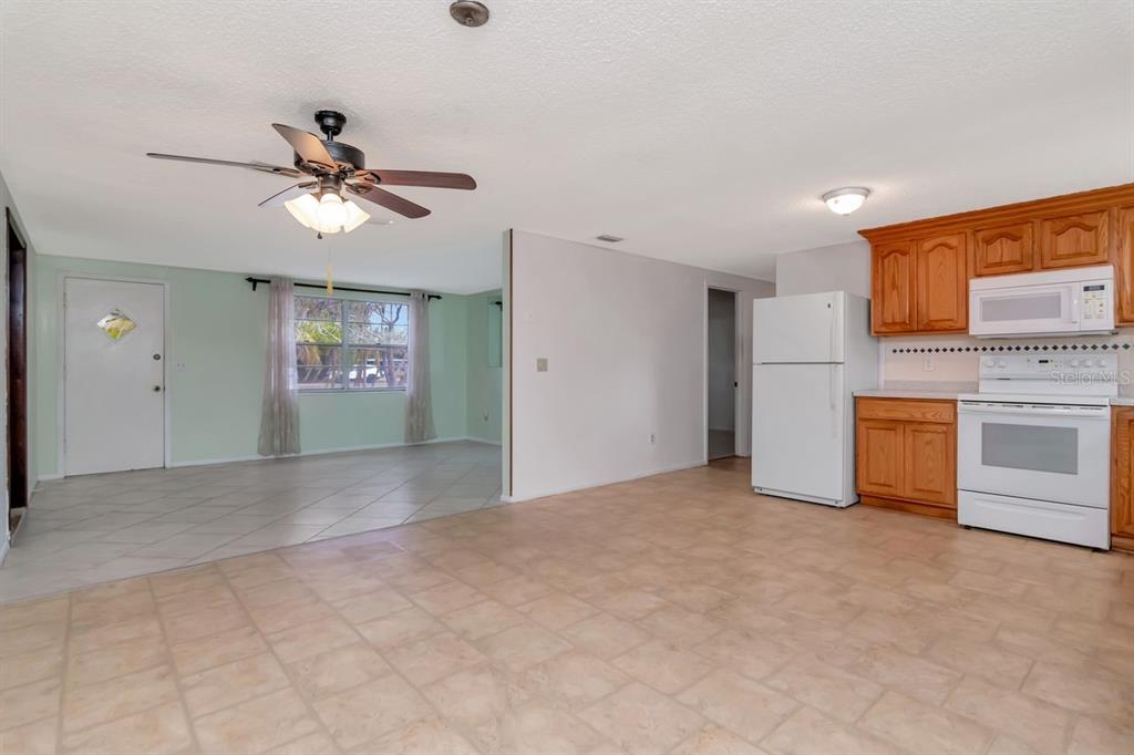 349 Old Welcome Road Lithia, FL 33547 - Photo 11 of 54 a view of a kitchen with a stove cabinets a ceiling fan and a wooden floor