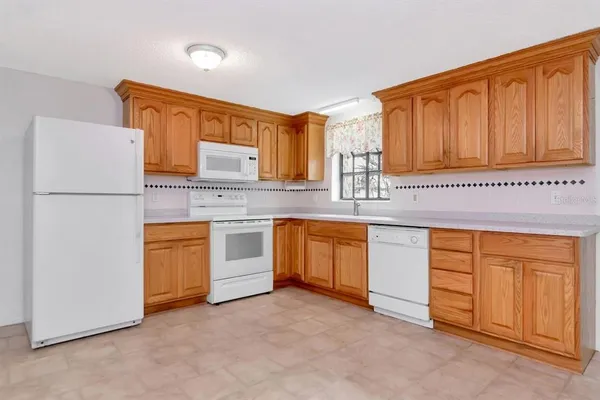 a kitchen with granite countertop a sink cabinets stainless steel appliances and a window