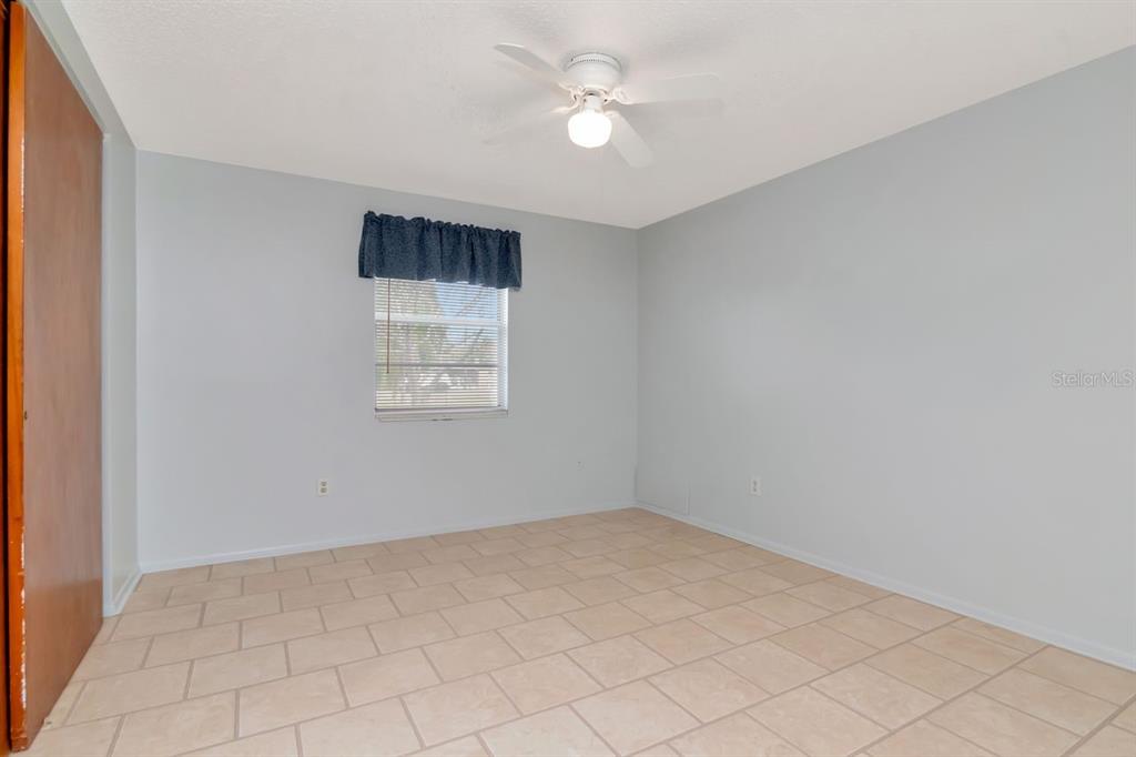 349 Old Welcome Road Lithia, FL 33547 - Photo 26 of 54 an empty room with a chandelier fan and windows