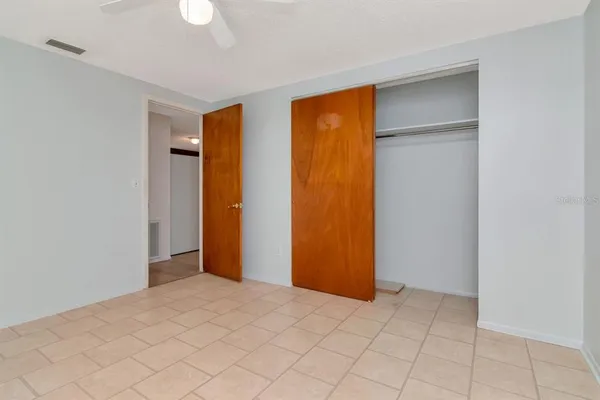 a view of an empty room with closet and a window