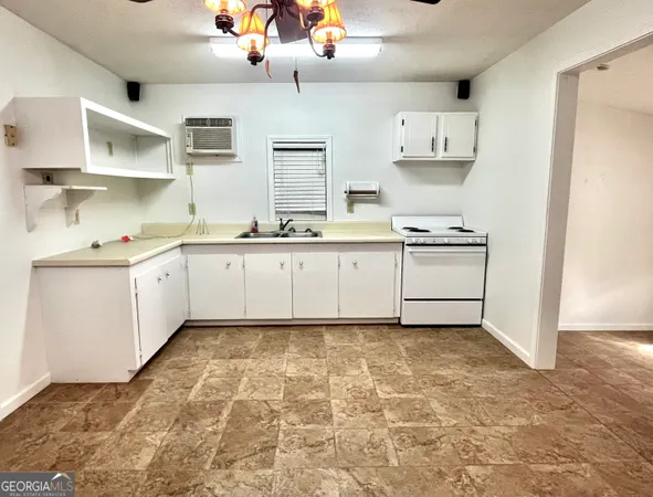 a kitchen with granite countertop a sink and cabinets