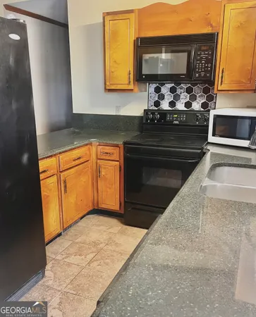 a kitchen with granite countertop a stove and a sink