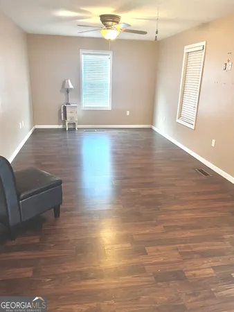a view of empty room with window and wooden floor